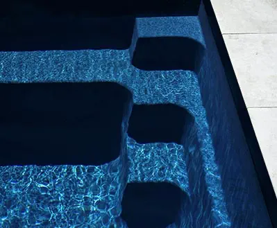 Leisure Pools fibreglass pool in Ebony Blue showing deep, reflective dark blue water.