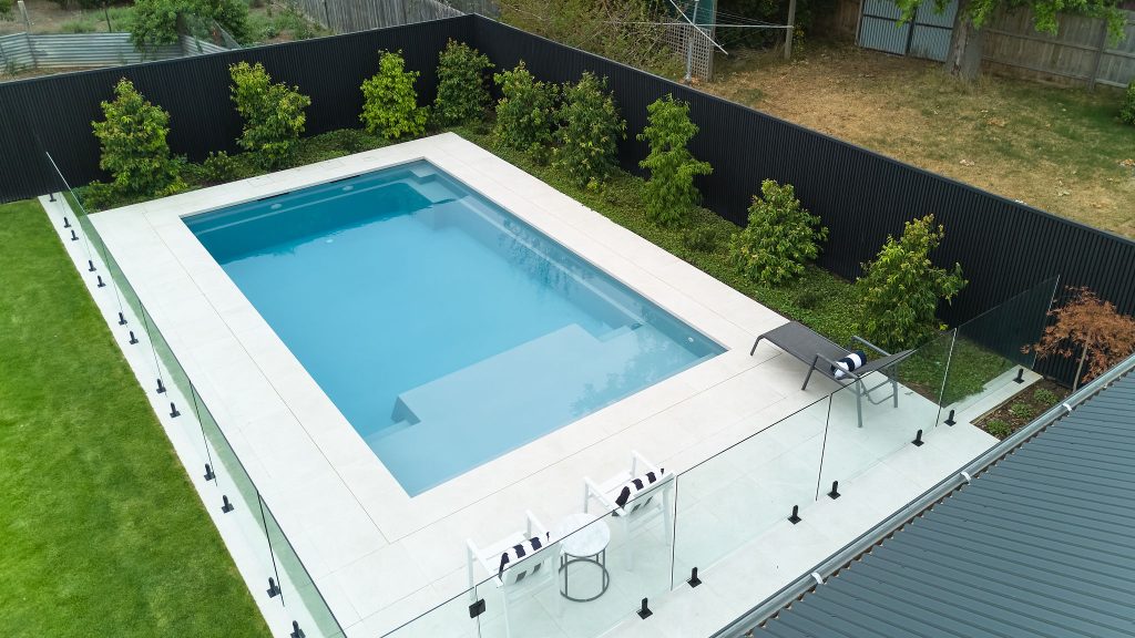 Leisure Pools Acclaim 8 in Silver Grey with stone pavers, glass fencing and established garden beds, Bacchus Marsh